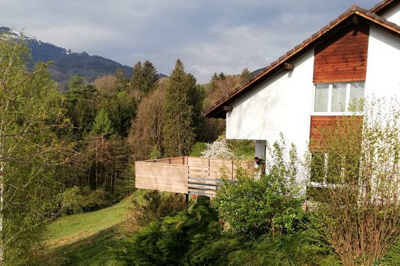 Balkon; Stahlkonstruktion auf Betonfundamente abgestützt und Rohrgeländer mit Holz beplankt