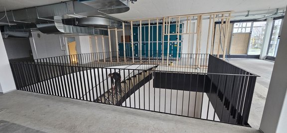 Innentreppe; Stahlpodest; Rauchschürzen und Staketengeländer als Absturzsicherung